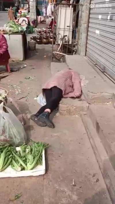 女子倒下，众人围观