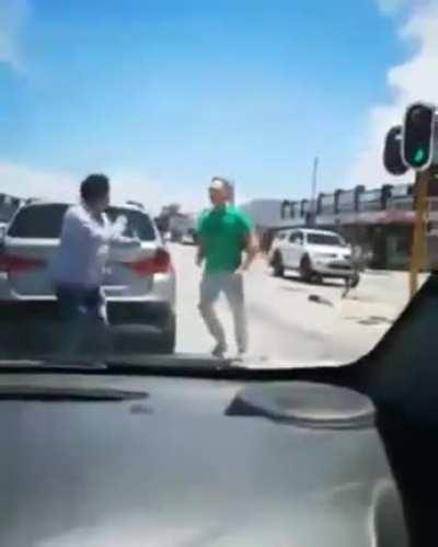 man get punched after throwing rock at other car