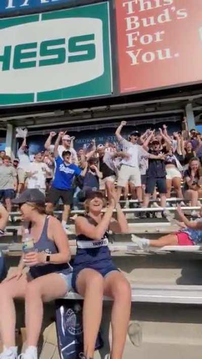 Yankees fans cheer a little girl landing a bottle flip