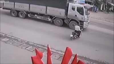 Idiot on a motorbike almost gets run over by a truck!