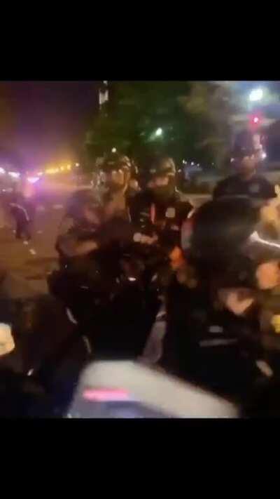 Two officers aggressively forced out of kneeling for solidarity with protestors.