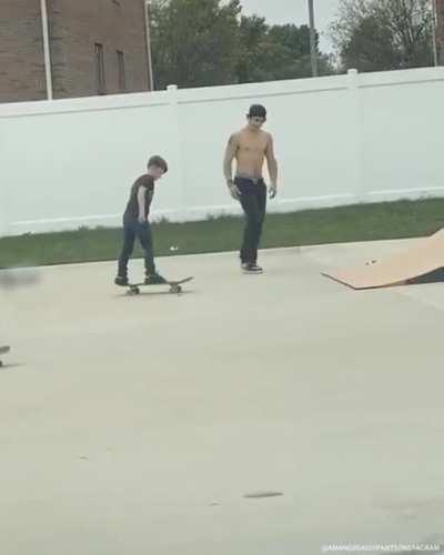 A big skater dude helping a small skater dude