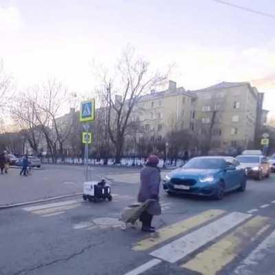 Babushka helps a delivery robot to cross a street