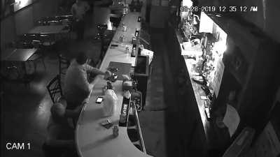 Patron fresh out of fucks left to give casually observers robbery happen around him with mild interest.