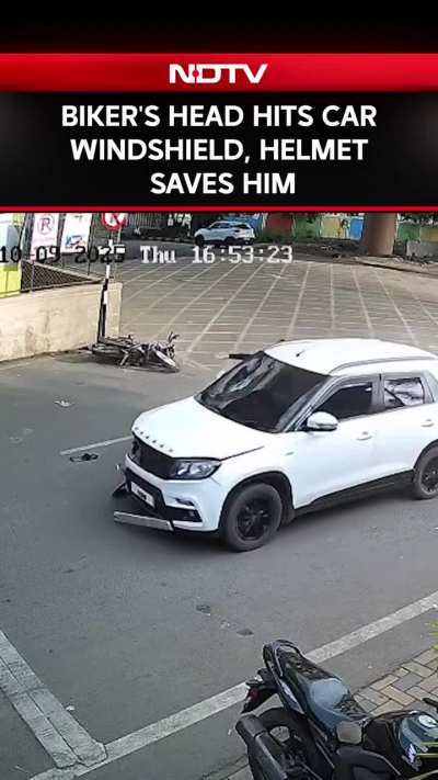 A speeding biker collided head-on with an approaching car, his head hits the front part of the car directly, The windshield shatters, and he falls to the ground a short distance away.
