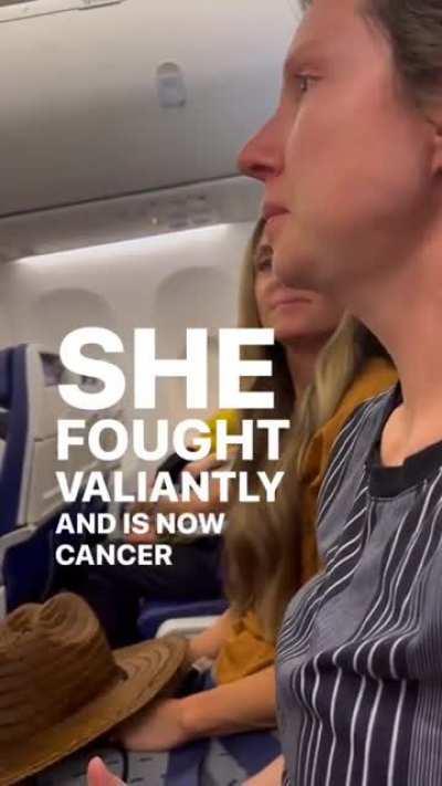 This passenger on a flight is suprised by the cabin crew after they announce she is cancer free.