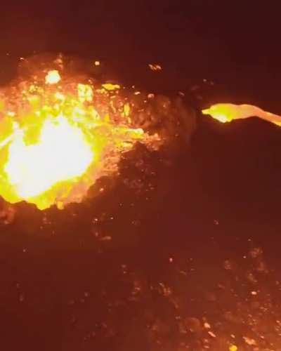 Дрон пролетает над извергающимся вулканом