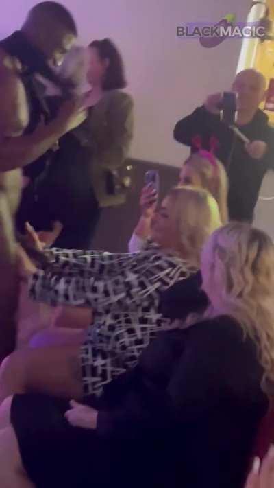 Male stripper Black Magic getting his huge cock stroked by blonde woman.