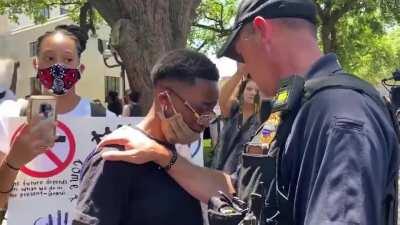 Shreveport Police Officer consoling a crying protestor.