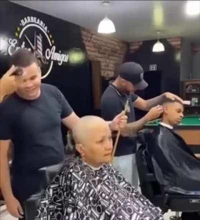 The barber cuts his own hair to give morel at the hairdresser where a cancer patient goes to have his hair shaved