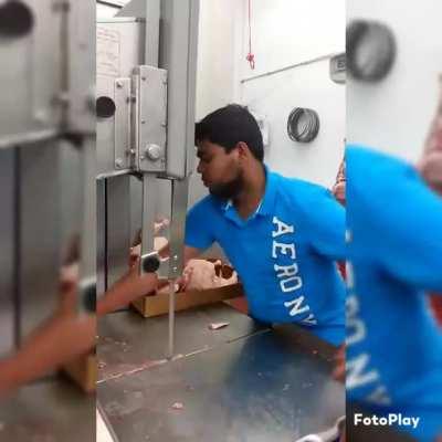 His hands' precision and the machine's smoothness in cutting the chicken