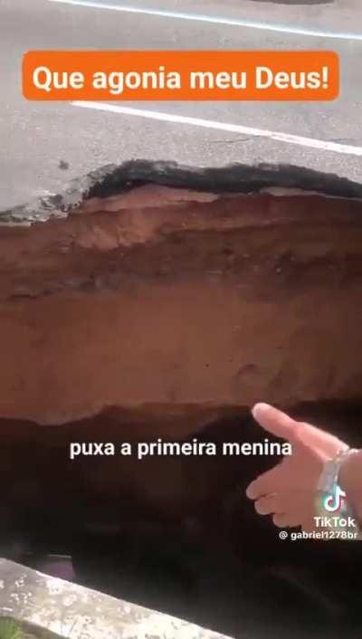 A big crater appears in the middle of the road in Brazil and a family gets stuck in it.