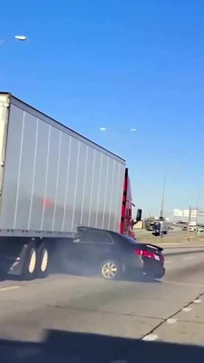 Semi Truck dragging car on freeway.