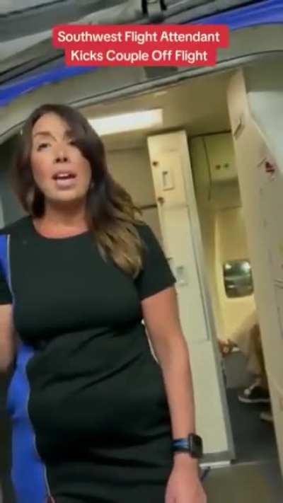 A flight attendant stops a couple from getting on the plane.