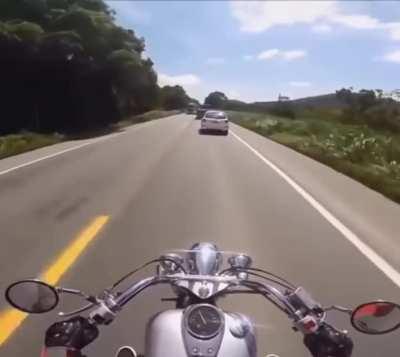 Car veers onto incoming traffic almost hitting motorcyclist