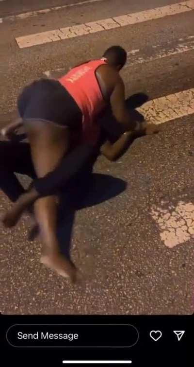 Two black women fight on a highway at night