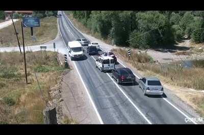 What happens when a car stops in front of a wedding convoy?