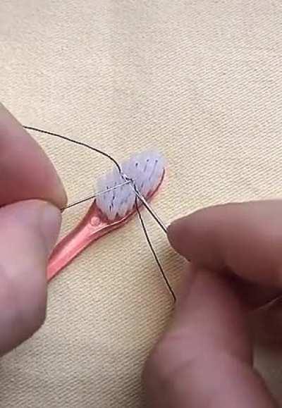Threading a needle with a toothbrush