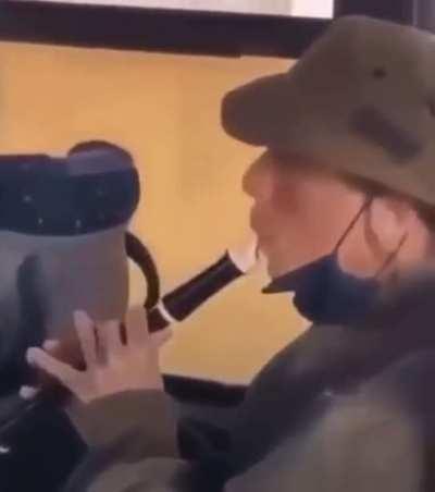 Man playing the flute inside bus, then tank
