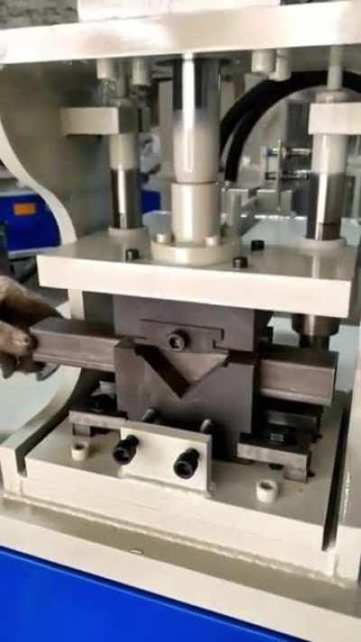 Machine cuts tubular steel so it can be bent into a right angle