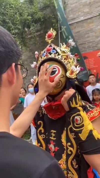 A Bian Lian artist changes his mask in no time.