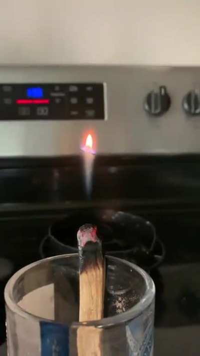 A Palo Santo wood stick producing smoke, smoke contains unspent fuel that can ignite