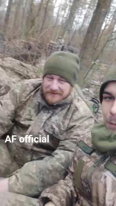 Band of brothers: A Ukrainian squad warm themselves around the campfire.