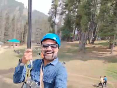 Guy takes the zipline as gun men below starts shooting people