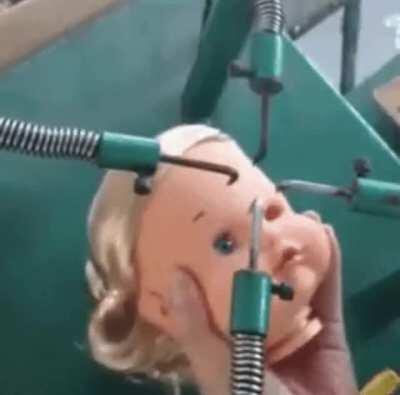 Finishing touches on a baby doll face.