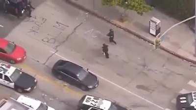 Cops fall off truck, then one wildly pepper sprays the air for no reason.