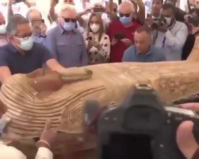 Archaeologists in Egypt opening an ancient coffin sealed 2,500 years ago.