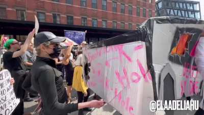 Protesters bring a smashed up model Cybertruck outside of Elon Musk’s NYC Tesla Showroom (3/29/2025)