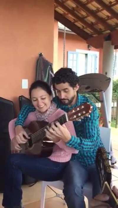 A couple playing one guitar