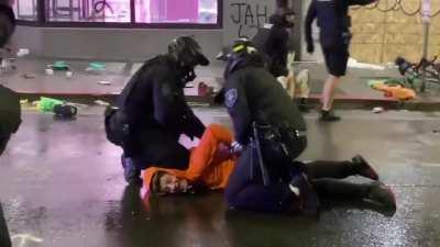Crowd shouts at a Seattle officer who put his knee on the neck an apprehended looter. Another officer listened & physically pulled his partner's knee off the neck.