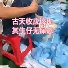 Man laughs as he wipes his shoes on face masks before they are packed, boxed and shipped abroad.