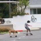 A dude skating with his dog